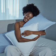 Woman relaxing with cool-touch Frostmoor pillows at dawn