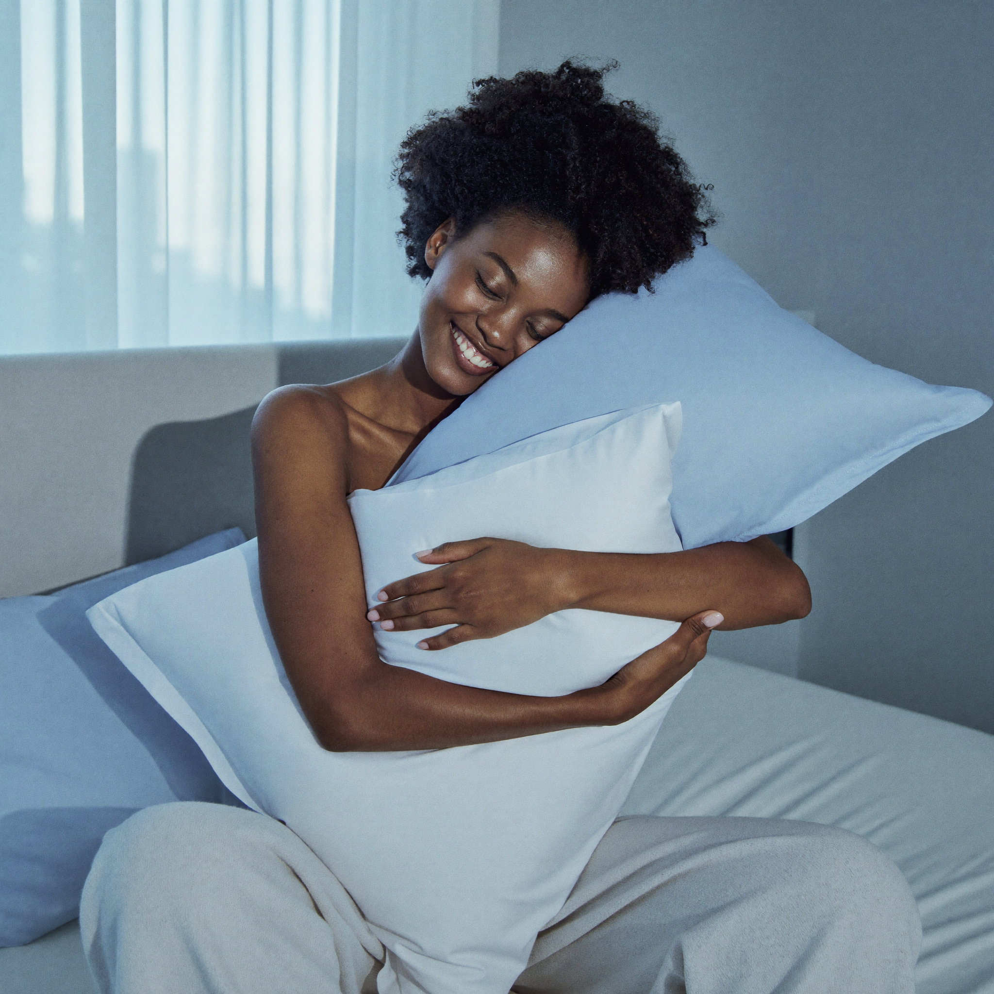 Woman relaxing with cool-touch Frostmoor pillows at dawn